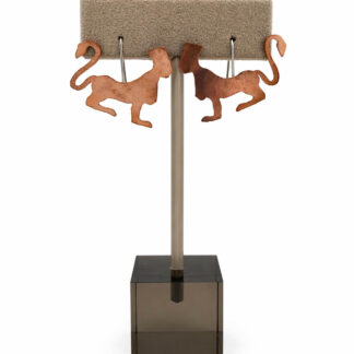 Sphinx earring in copper by Vulgar Dreamer. Displayed on earring stand.